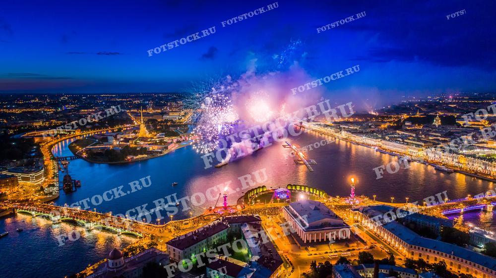 Эта захватывающая аэрофотосъемка Санкт-Петербурга демонстрирует фейерверк во время праздничного мероприятия, возможно, в рамках празднования "Алых парусов". Снимок выполнен с дрона, благодаря чему открывается панорамный вид на реку Неву, окружающие достопримечательности, включая Дворцовый мост и Зимний дворец. Фотография идеально подходит для использования в туристических публикациях, культурно-исторических статьях и в качестве учебных материалов.